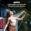 Mujer usando una ducha portátil Tiny Shower junto a su coche durante un viaje de camping al aire libre