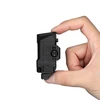 Mano sosteniendo mini linterna táctica Olight negra compacta sobre fondo blanco