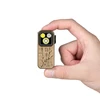Linterna de clip Olight Oclip Pro color dorado sostenida por una mano, con grabado jeroglífico y luz compacta para uso diario