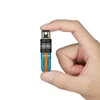 Mano sosteniendo la linterna azul y naranja Olight Imini, portátil, ligera, recargable.