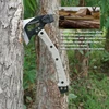 Hacha táctica de supervivencia clavada en árbol con mango beige y hoja de acero inoxidable para camping y aventura