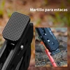 Martillo para estacas de camping negro con textura antideslizante clavando una pica roja en el suelo