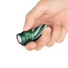 Linterna compacta Olight Baton 3 verde y blanco, sostenida en mano, con cuerpo texturizado y botón lateral para uso diario.