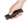 Mano sosteniendo una linterna recargable Olight plana de color negro con interruptor giratorio sobre fondo oscuro